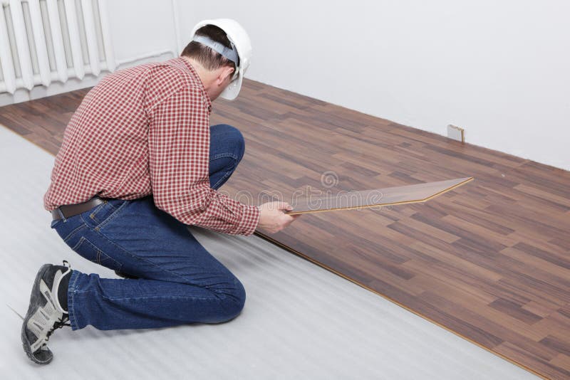 Man making the laminate flooring installation. Man making the laminate flooring installation