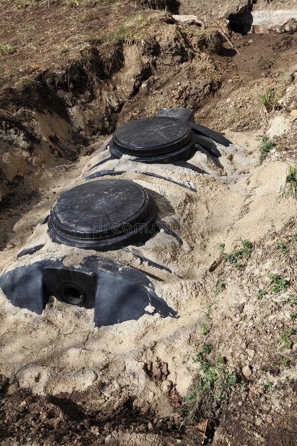 A vertical close up of a newly installed septic tank system at a residential property for removal and purification of household grey wastewater and sewage. A vertical close up of a newly installed septic tank system at a residential property for removal and purification of household grey wastewater and sewage.