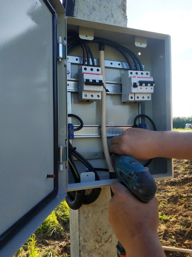 Installing and Connecting an Electrical Panel on the Street Stock Photo
