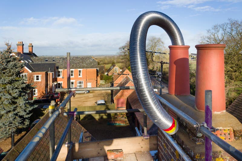 Installing flue liner in a chimney, UK. Installing a flexible steel flue liner into a chimney during a wood burning stove installation, UK stock image Installing flue liner in a chimney, UK. Installing a flexible steel flue liner into a chimney during a wood burning stove installation, UK stock image