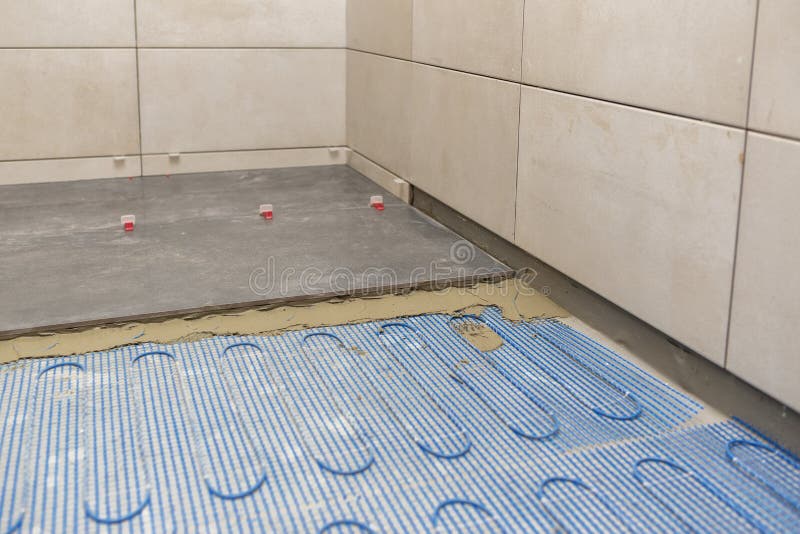 Installing a Floor Heating System Under Ceramic Tiles in Bathroom Stock
