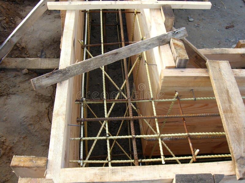 Installing wooden forms for pouring the Foundation concrete trench reinforced with reinforcement made of fiberglass royalty free stock photos Installing wooden forms for pouring the Foundation concrete trench reinforced with reinforcement made of fiberglass royalty free stock photos