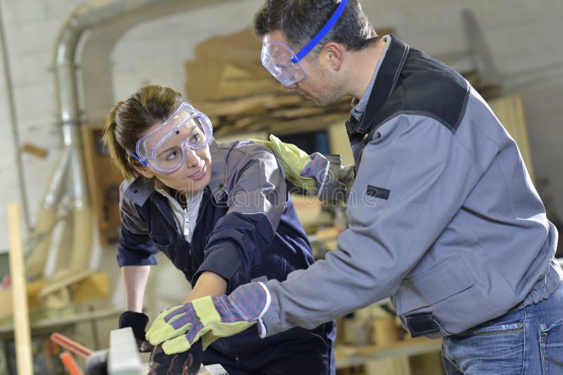 Instructeur die het werk van het stagiairtimmerwerk tonen stock afbeeldingen Instructeur die het werk van het stagiairtimmerwerk tonen stock afbeeldingen