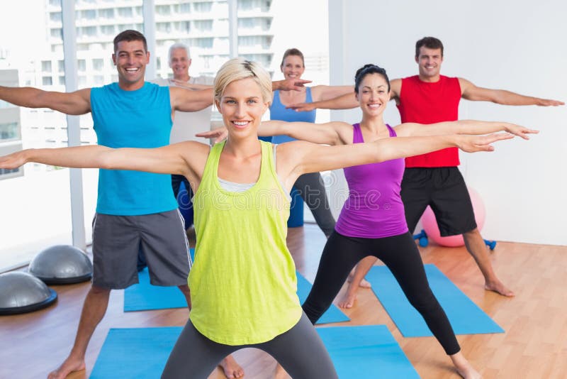 Instructor with class exercising in fitness club stock photos