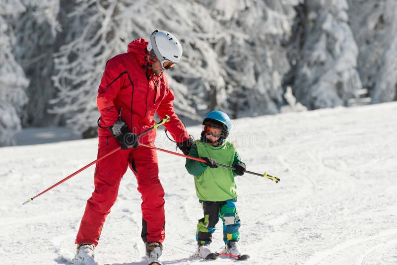 Instructor de esquí con un niño pequeño imagen de archivo