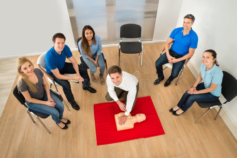 Elevated View Of First Aid Instructor Showing Resuscitation Technique On Dummy. Elevated View Of First Aid Instructor Showing Resuscitation Technique On Dummy