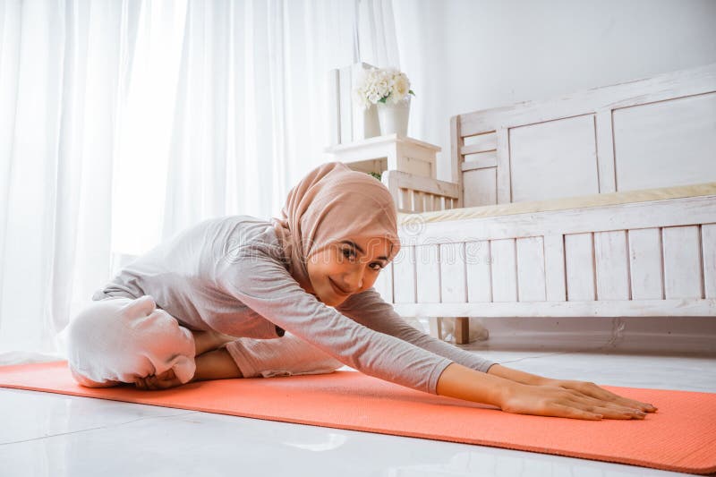 Instructora musulmana con hijab haciendo pilates de yoga posando en colchón fotos de archivo libres de regalías
