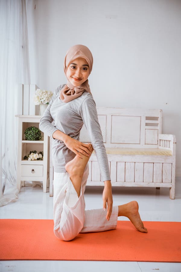 Instructora musulmana con hijab haciendo pilates de yoga posando en colchón imagen de archivo