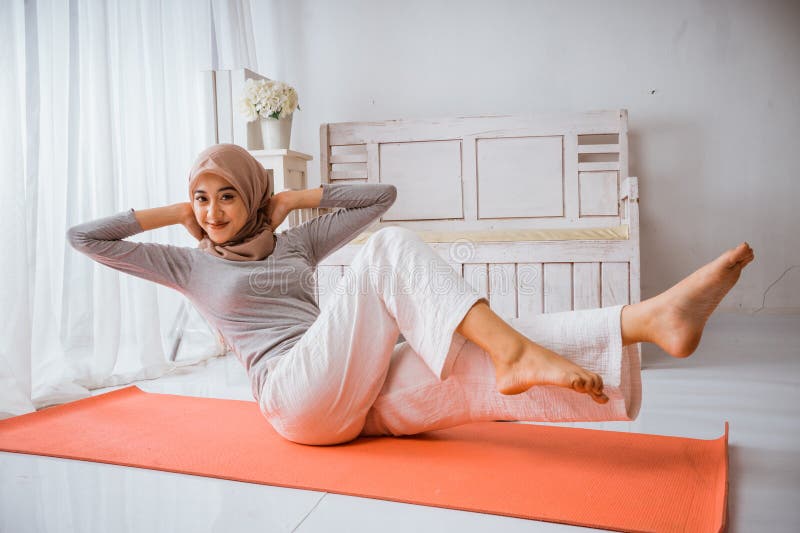 Instructora musulmana con hijab haciendo pilates de yoga posando en colchón fotografía de archivo libre de regalías