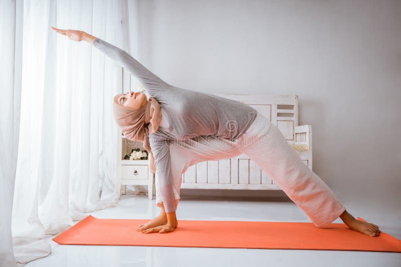 Instructora musulmana con hijab haciendo pilates de yoga posando en colchón foto de archivo libre de regalías