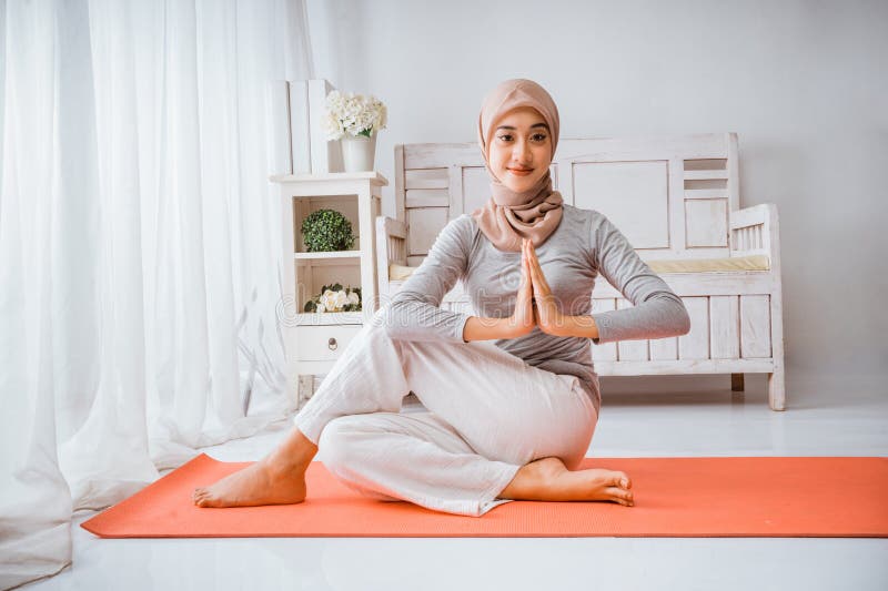 Instructora musulmana con pilates hijab yoga mitad pez posando colchón fotos de archivo