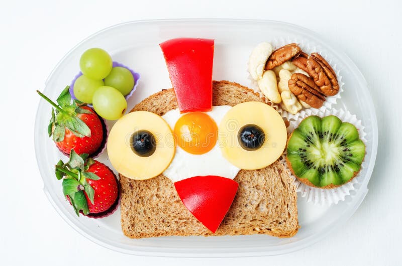 Instruisez la gamelle pour des enfants avec la nourriture sous forme de visages drôles image stock Instruisez la gamelle pour des enfants avec la nourriture sous forme de visages drôles image stock