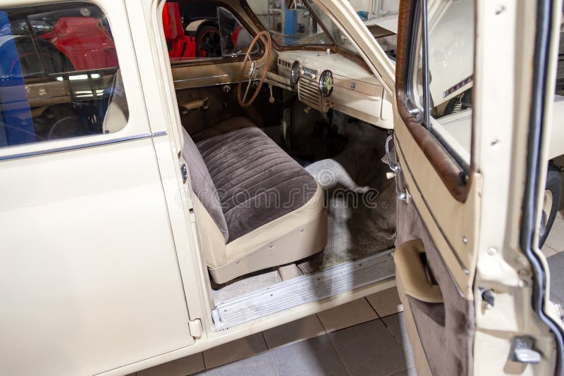 Novosibirsk, Russia - 01. 30. 19: Instruments and panel with steering wheel, seat and opened front door of the old Russian car of the executive class released in the Soviet Union beige GAZ m-20 pobeda