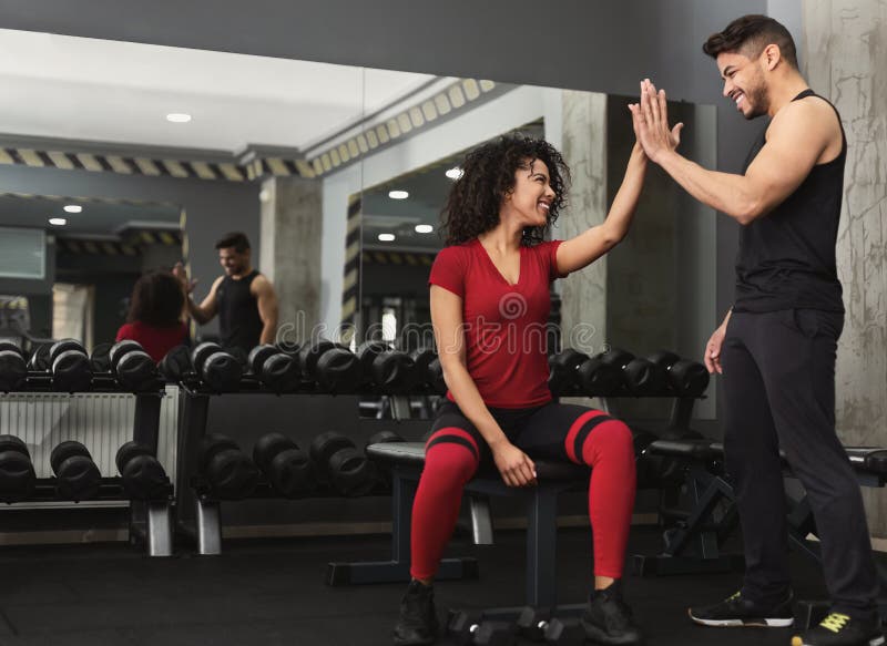 Instrutor e mulher da aptidão que dão-se cinco altos imagens de stock Instrutor e mulher da aptidão que dão-se cinco altos imagens de stock