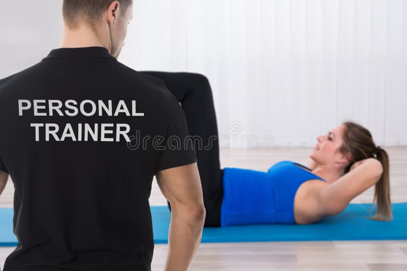Instrutor pessoal Looking At Woman que faz o exercício