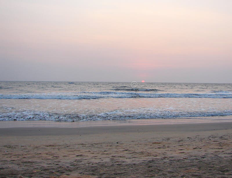 Inställning av den röda solen på horisonten över havet på den Payyambalam stranden, Kannur, Kerala, Indien royaltyfria bilder Inställning av den röda solen på horisonten över havet på den Payyambalam stranden, Kannur, Kerala, Indien royaltyfria bilder