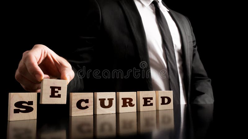 Insurance market concept - Businessman Arranging Small Wooden Blocks with word Secured on a Pure Black Background.