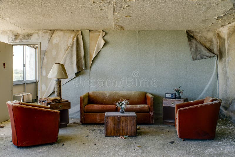 Intakter Unterbringungsraum mit gebrannten orange Stühlen u. Couch - verlassenes Hotel