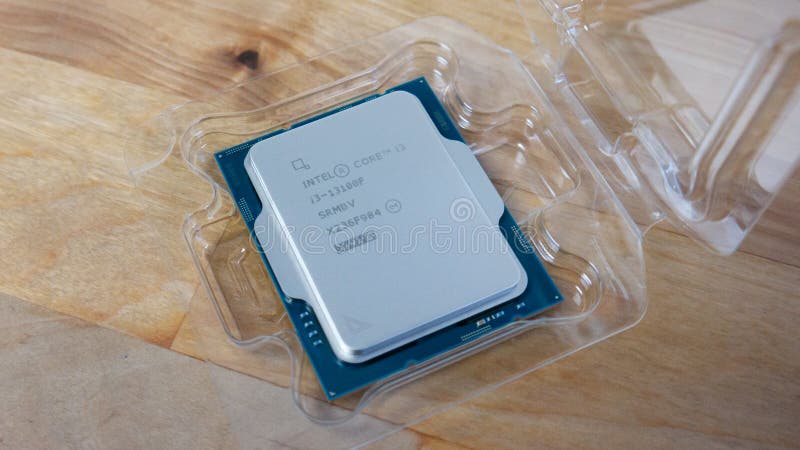 Intel Core i3-13100f Raptor Lake computer processor or CPU on a wooden table in plastic clamshell holder. Intel Core i3-13100f Raptor Lake computer processor or CPU on a wooden table in plastic clamshell holder.