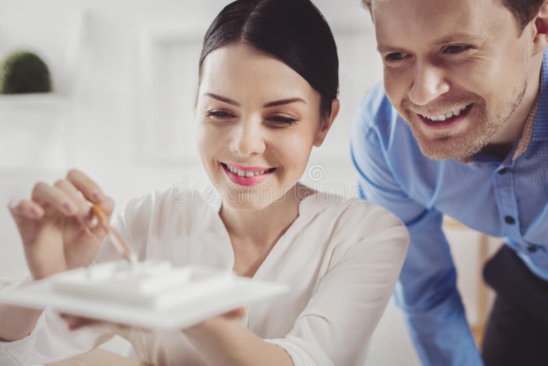 Intelligente junge Frau, die zusammen mit ihrem Kollegen sitzt lizenzfreies stockfoto