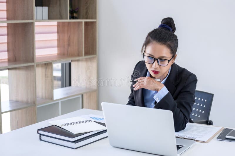Intelligente vrouwelijke onderneemster die aan laptop werken terwijl analysi royalty-vrije stock fotografie Intelligente vrouwelijke onderneemster die aan laptop werken terwijl analysi royalty-vrije stock fotografie