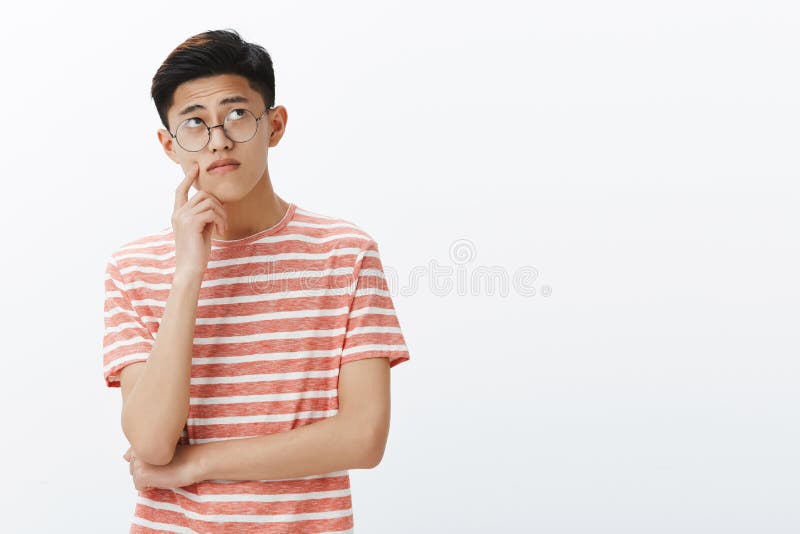 Intelligenter asiatischer Kerl, der Puzzlespiel im Verstand betrachtet durchdacht und entspannt oberer rechter Ecke, Denken, mach stockfotografie Intelligenter asiatischer Kerl, der Puzzlespiel im Verstand betrachtet durchdacht und entspannt oberer rechter Ecke, Denken, mach stockfotografie