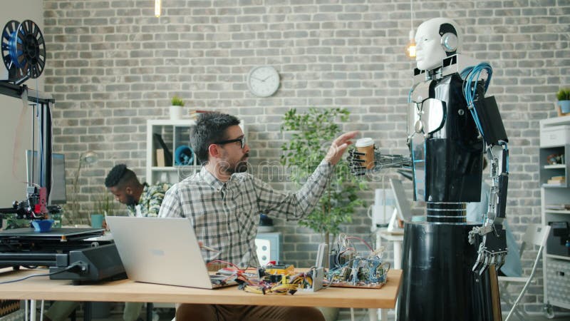 Intelligenter Roboter, der Kaffee zu Ingenieuren bringt, die im Büro arbeiten, Typ, der trinkt stock video footage