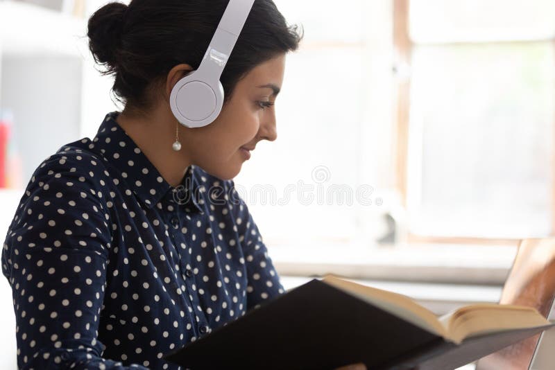 Intelligentes indisches Mädchen in den Kopfhörern studierend am Laptop lizenzfreie stockbilder Intelligentes indisches Mädchen in den Kopfhörern studierend am Laptop lizenzfreie stockbilder