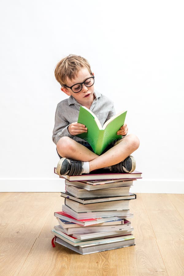 Intelligentes Kleinkind, das ein Buch auf Stapel von Klugheit liest lizenzfreie stockbilder Intelligentes Kleinkind, das ein Buch auf Stapel von Klugheit liest lizenzfreie stockbilder
