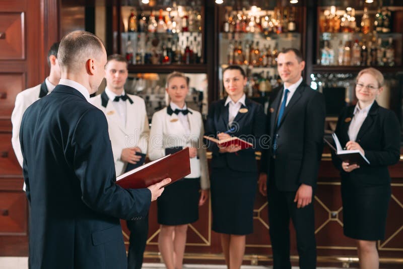The interaction of the staff. Hotel or restaurant manager and his staff in kitchen. interacting to head chef in royalty free stock images