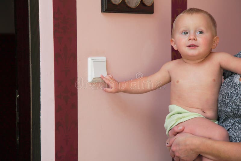 Interested little boy turning off the light-switch