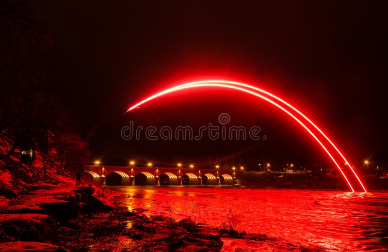 Interesting red fireworks, river Venta and red brick bridge in Kuldiga, Latvia royalty free stock photography