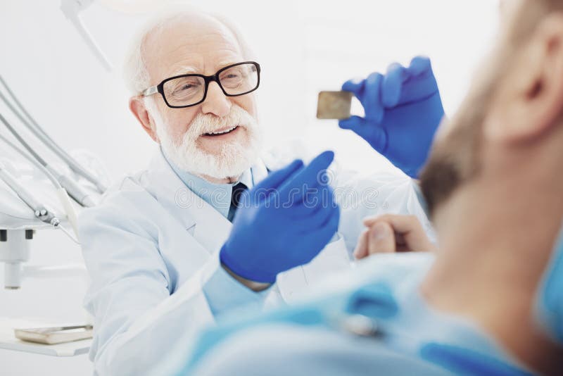 Interesujący męski dentysta daje wyjaśnieniu obraz stock Interesujący męski dentysta daje wyjaśnieniu obraz stock