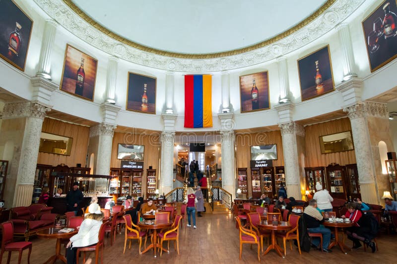 Interior of the Armenia pavilion in VDNKh park, people have drinks.