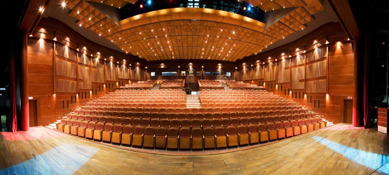 Panoramic view of a modern theater interior with red seats. Panoramic view of a modern theater interior with red seats.