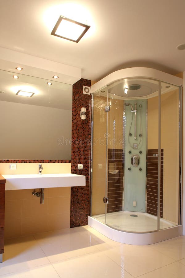 An interior view of the sink and shower of a spacious bathroom. An interior view of the sink and shower of a spacious bathroom.