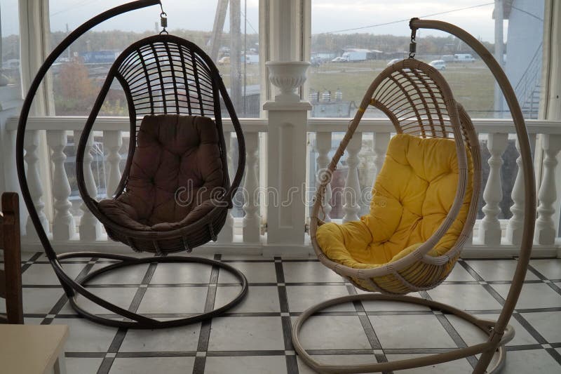 The Interior of the Cafe Hall with Tables and Cozy Swing Chairs. Stock