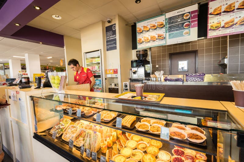 Gas station store interior in France. Customers are paying at the cash register inside a gas station shop. Photo taken on: Septembre 12, 2015. Gas station store interior in France. Customers are paying at the cash register inside a gas station shop. Photo taken on: Septembre 12, 2015.