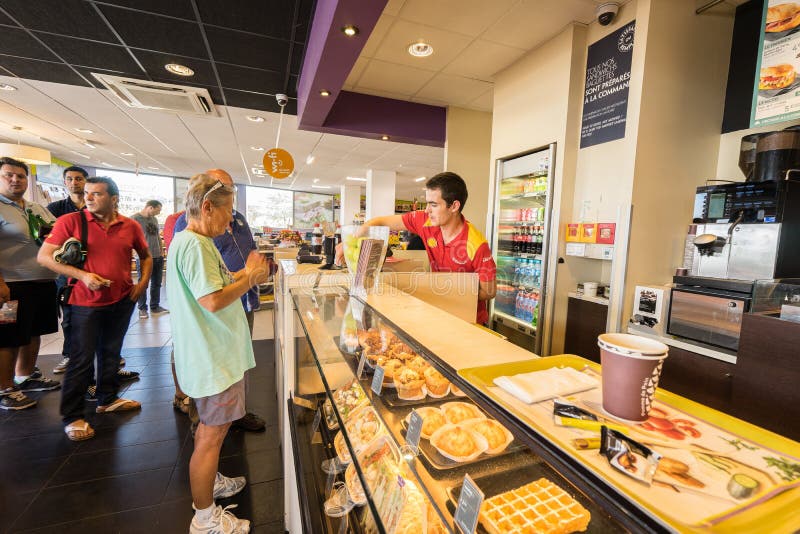 Gas station store interior in France.Customers are paying at the cash register inside a gas station shop. Photo taken on: Septembre 12, 2015. Gas station store interior in France.Customers are paying at the cash register inside a gas station shop. Photo taken on: Septembre 12, 2015.