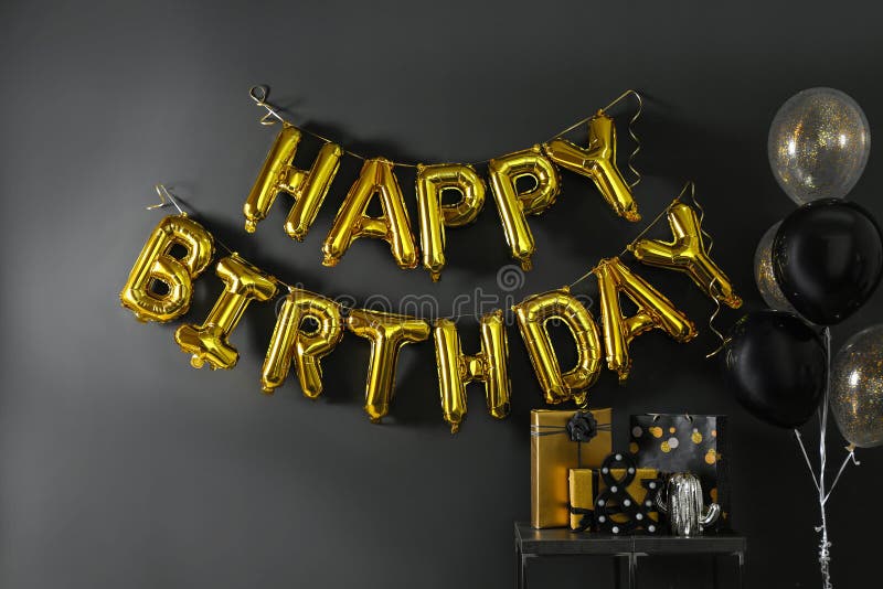 Room interior with gift boxes and phrase HAPPY BIRTHDAY made of golden balloon letters. Room interior with gift boxes and phrase HAPPY BIRTHDAY made of golden balloon letters
