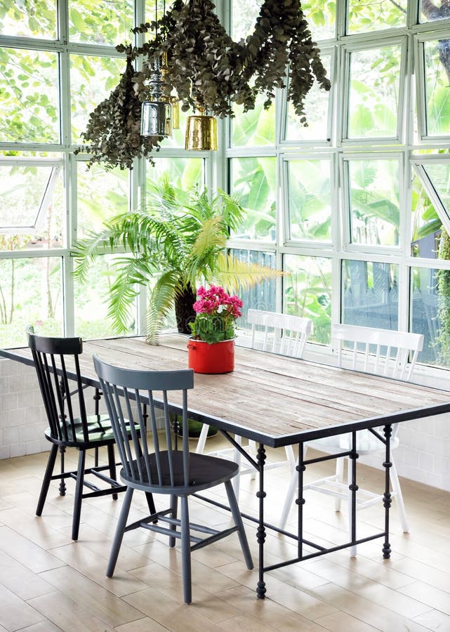 Interior da sala de jantar com tabela, cadeiras e plantas contra w grande fotos de stock Interior da sala de jantar com tabela, cadeiras e plantas contra w grande fotos de stock