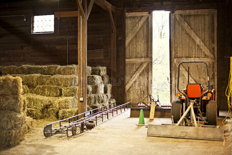 Interior del granero con las balas de heno y el equipo de granja