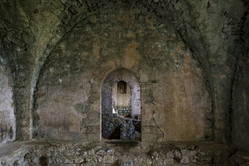 Interior del pasillo arruinado con las paredes y el pasillo agrietados, dañados en el castillo antiguo del St Hilarion, Kyrenia foto de archivo Interior del pasillo arruinado con las paredes y el pasillo agrietados, dañados en el castillo antiguo del St Hilarion, Kyrenia foto de archivo