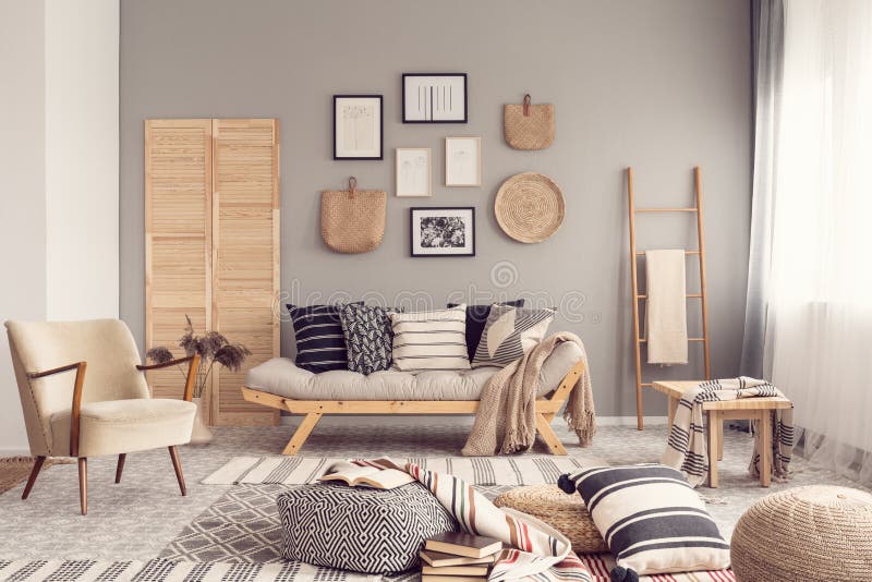 Interior design alla moda del salone con il divano scandinavo, la parete grigia e gli accenti naturali fotografie stock libere da diritti