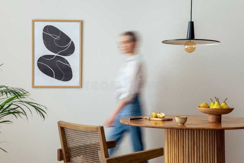 Interior design of domestic dining room space with two mock up poster frames, round table, chair, pedant lamp, decoration and
