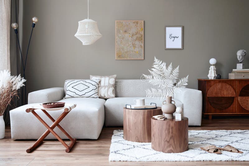 Interior design of stylish living room with modern neutral sofa, furniture, mock up poster frames, dried flowers in vase, coffee.