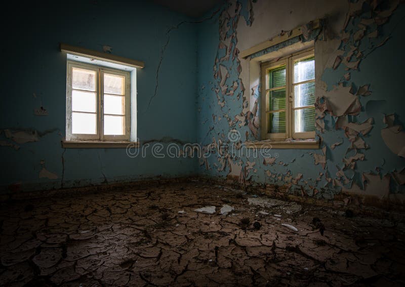 Interior of a dirty and empty demolished abandoned with open window and dry cracked mud. Interior of a dirty and empty demolished abandoned with open window and dry cracked mud