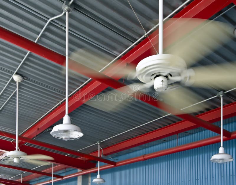 Ceiling of the waiting area of an industrial design structure, including ceiling fans, lighting, and red steel beams. Industrial lights stock images, royalty-free photos and pictures