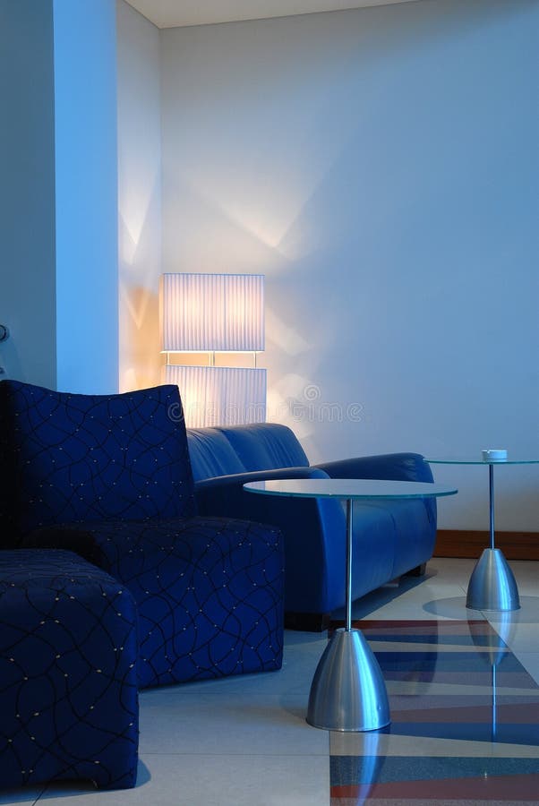 Trendy obývacia izba gauč, stoličky a stoly, všetko v modrej farby.
