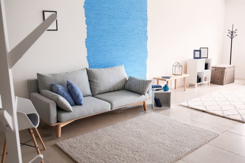Interior of living room with stylish comfortable sofa near colorful wall stock photos Interior of living room with stylish comfortable sofa near colorful wall stock photos